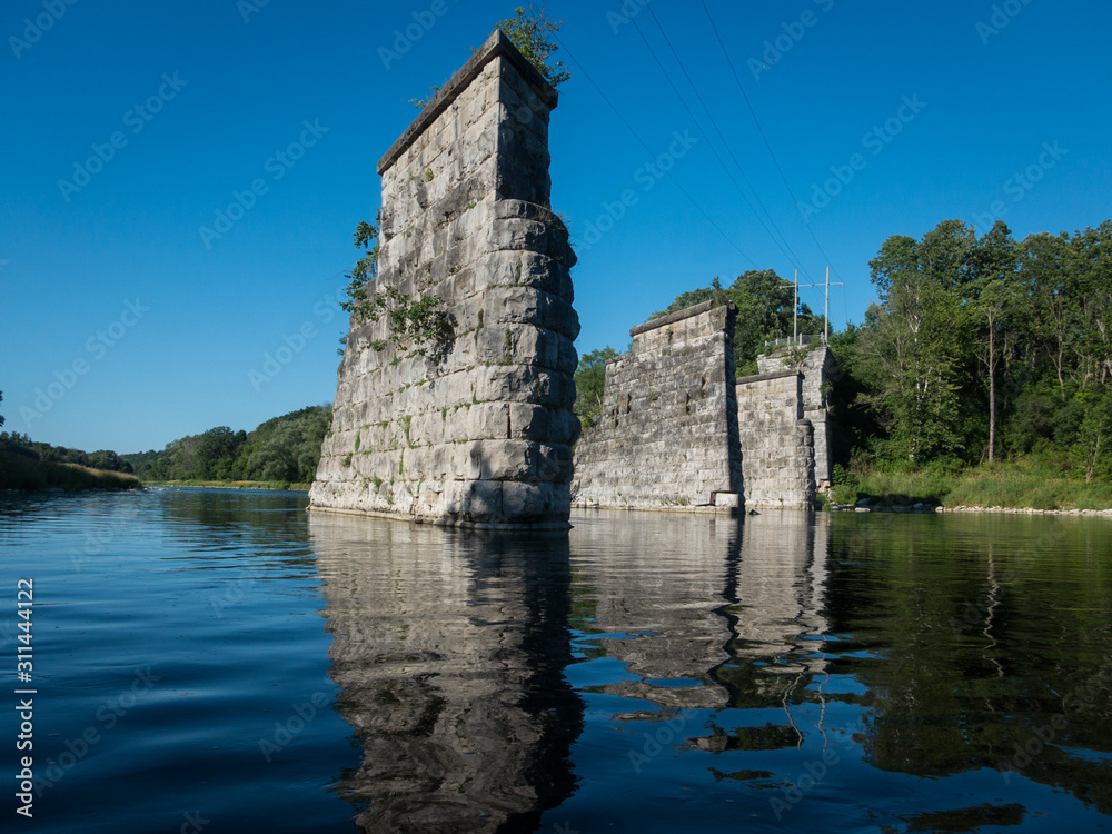 Abandoned and crumbled bridge pillar shot from river in Ontario