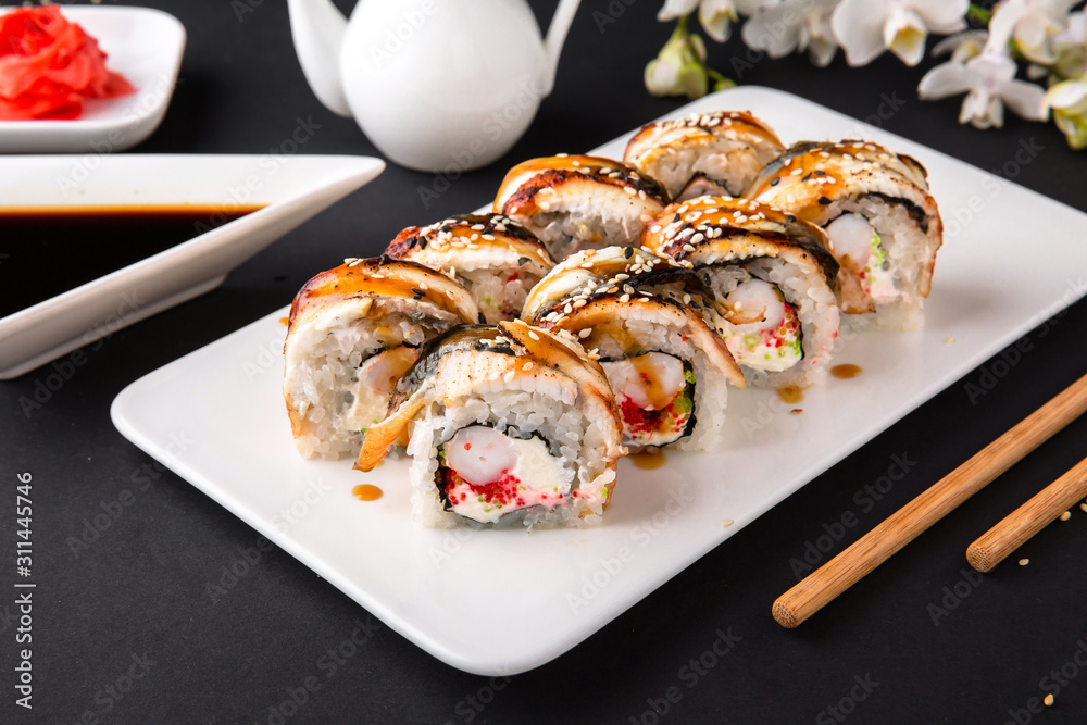 Unagi roll with smoked eel, with royal shrimp avocado, cream with Philadelphia cheese, tobiko caviar. Sushi menu. Japanese food. Unagi roll with smoked eel, with royal shrimp avocado, cream with Philadelphia cheese, tobiko caviar. Sushi menu. Japanese food.