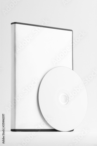Box with a CD or DVD in front of with a blank white surface.