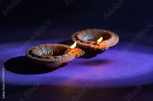 Clay diya lamps lit during Diwali Celebration. Greetings Card Design Indian Hindu Light Festival called Diwali photo