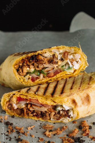 Shawarma sandwich gyro fresh roll of lavash pita bread chicken beef shawarma falafel RecipeTin Eatsfilled with grilled meat, mushrooms, cheese. Traditional Middle Eastern snack. On peper background