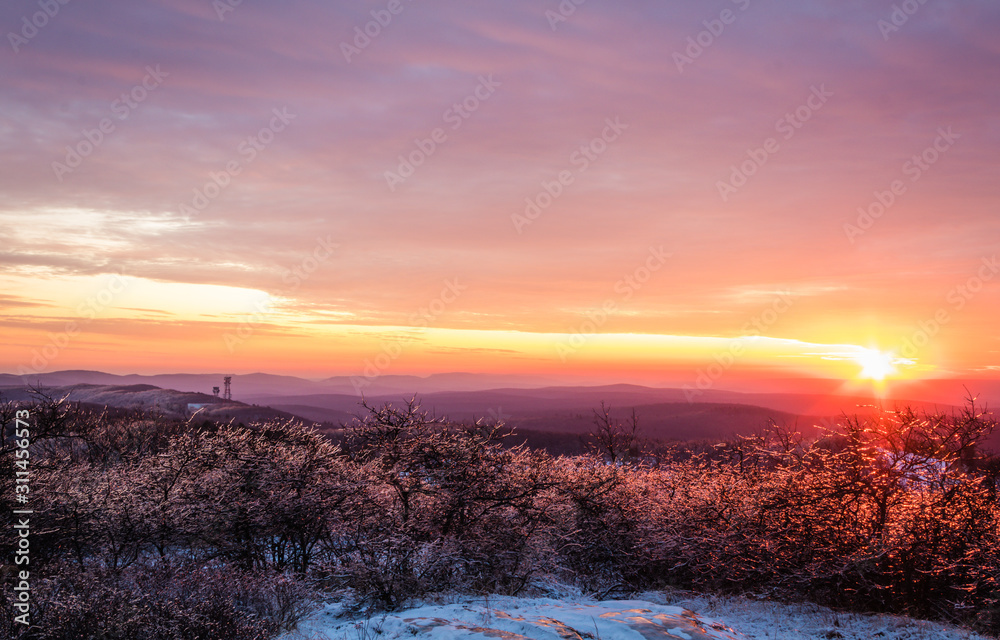 Vivid stunning sunset at High Point State Park, top of NJ, first day of winter covered in ice and snow Vivid stunning sunset at High Point State Park, top of NJ, first day of winter covered in ice and snow
