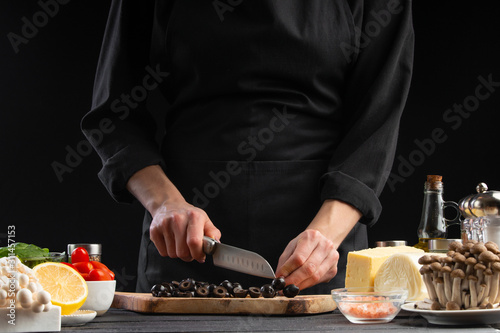 The chef cuts Italian masks to prepare a delicious and fresh salad. Vegetarian and fresh food, gastronomy and cooking, a recipe book and recipes for home cooking