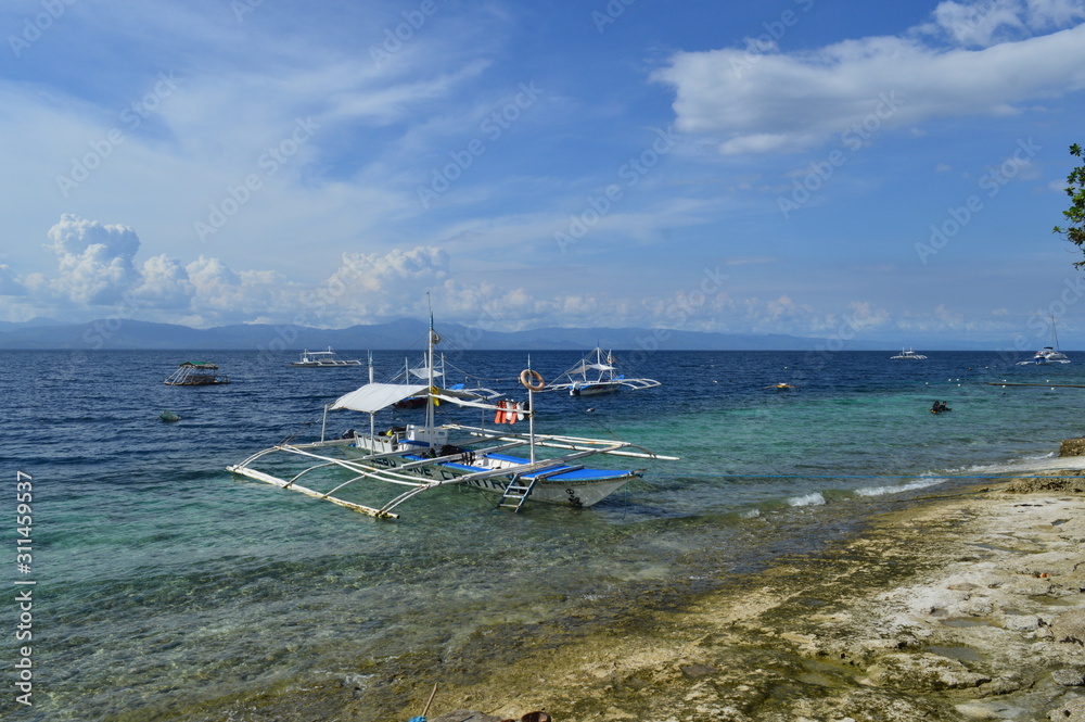 Double outrigger pump boat (Paraw) anchored close to the beach in Moalboal , Philippines