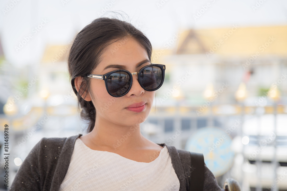 Portrait Of Young Women Wearing Sunglasses Standing On The Beach.