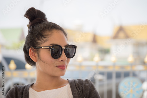 Fotografija Portrait of a beautiful young asian woman wearing sunglasses in the park with bo