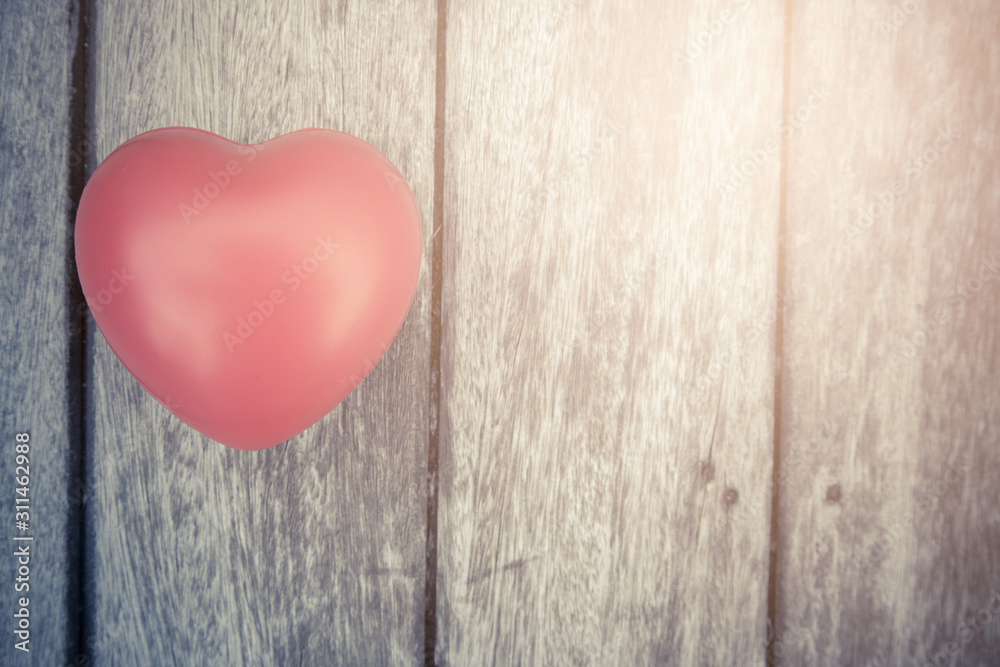 Red heart on wooden table