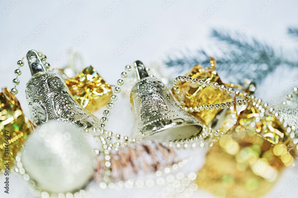 Fototapeta premium クリスマスオーナメントのベル。ぼやけたボール、ボックス、樅の枝、松毬。