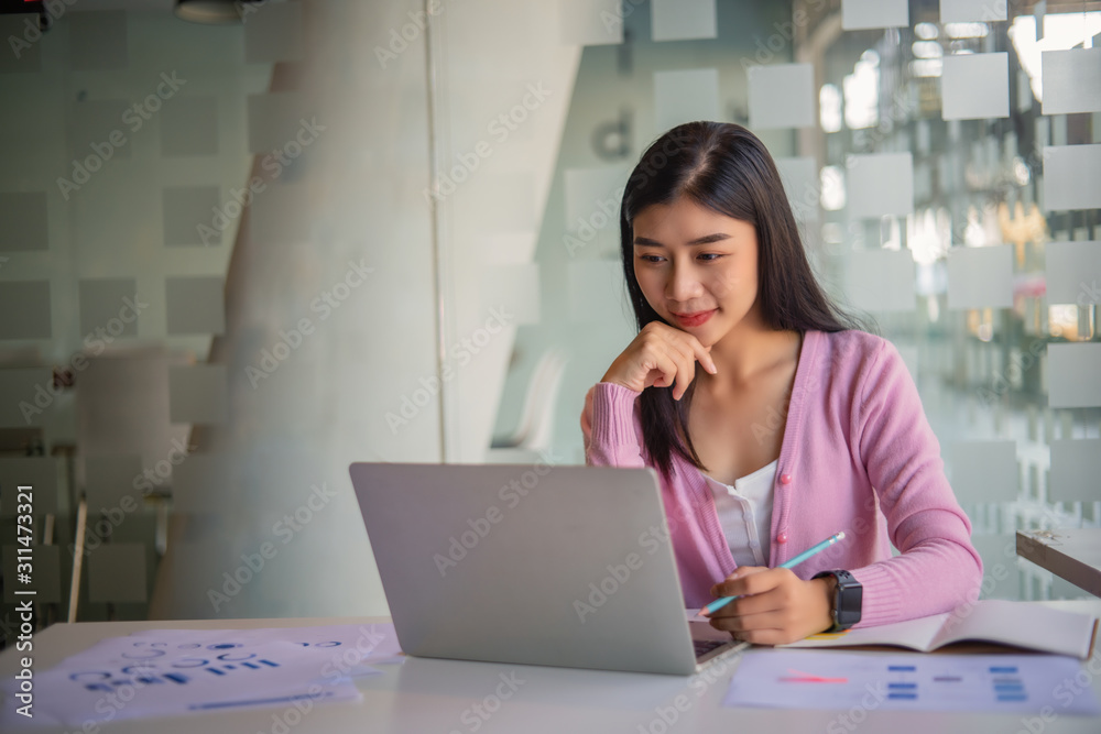 Portrait of pretty young woman using her laptop in the office. Portrait of pretty young woman using her laptop in the office.