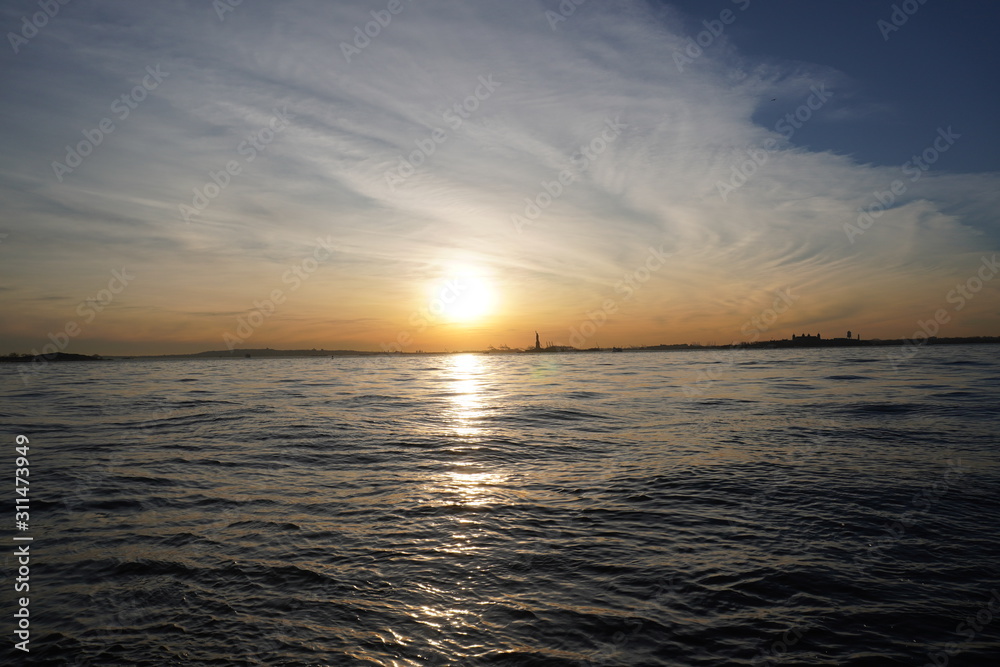 Obraz premium sunset over the sea statue of liberty New York City