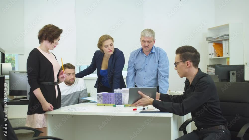 Engineer show something on tablet to his workmates Engineer show something on tablet to his workmates