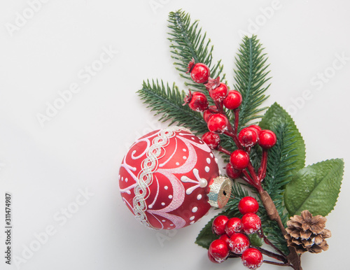 Christmas balls and berries on white table top view.