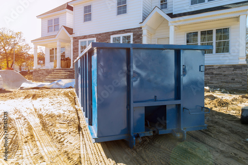 Blu dumpster, recycle waste and garbage bins near new construction site of appartment houses building photo