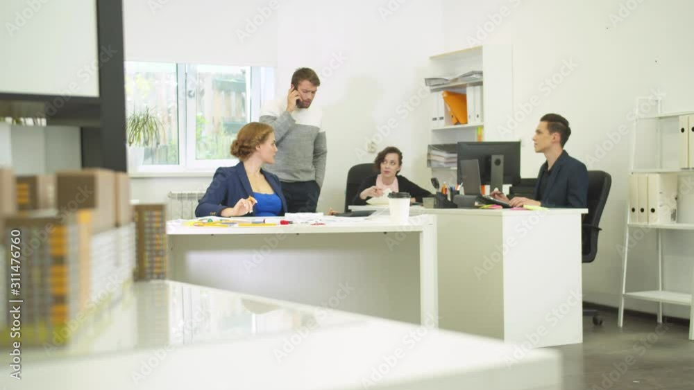 Man hang up the phone and tell great news in the office Man hang up the phone and tell great news in the office