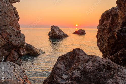 orange dawn in the early morning on the sea rocky shore