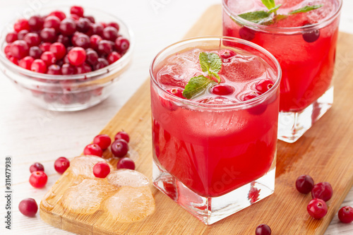 Red coctail with cranberry, vodka and ice. Refreshment drink.