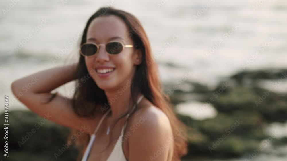 Medium shot. Happy Asian woman teens while dancing and laughing on the beach in the summer Thailand Medium shot. Happy Asian woman teens while dancing and laughing on the beach in the summer Thailand