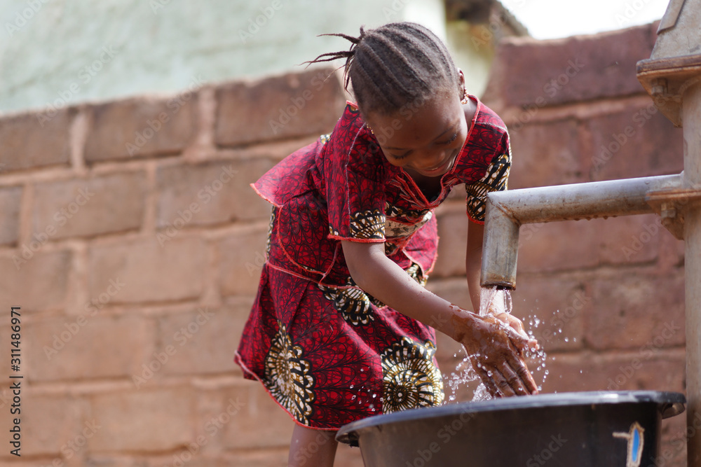 Young African Girl Cleaning Her Hands With Fresh Water At the Borehole