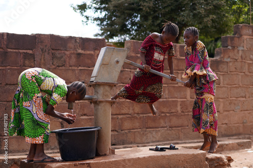 African Girls At A Public Borehole Pump Running Out Of Water photo