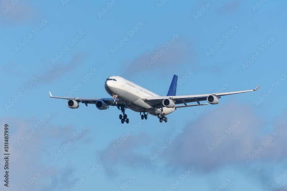 Airplane approach at the airport in the sky with clouds.