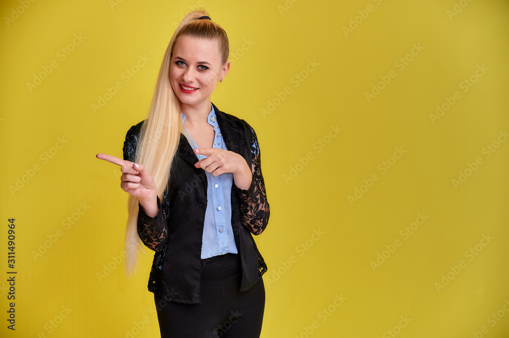 Portrait of a manager woman in a business suit with long beautiful hair and excellent make-up on a yellow background. Concept business blonde girl stands in front of the camera. Portrait of a manager woman in a business suit with long beautiful hair and excellent make-up on a yellow background. Concept business blonde girl stands in front of the camera.