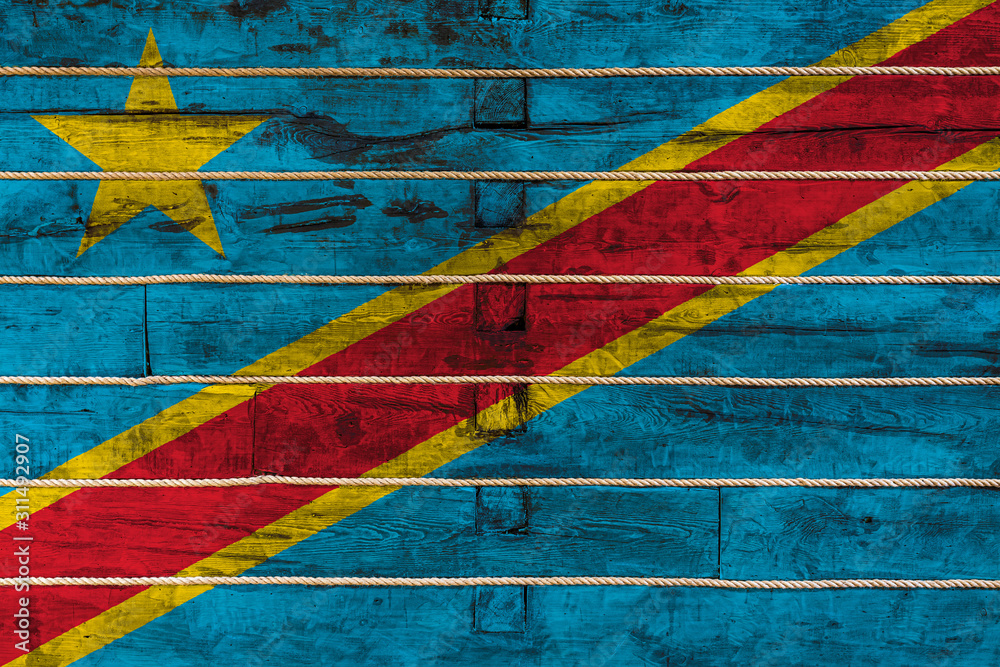 National flag  of Democratic Republic of the Congo on a wooden wall background. The concept of national pride and a symbol of the country. Flags painted on a wooden fence with a rope
