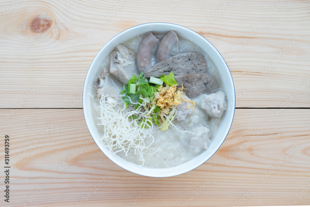 Congee with minced pork, braised pork filling, boiled pork liver, fried garlics minced pork in white bowl. Asian breakfast. Congee with minced pork, braised pork filling, boiled pork liver, fried garlics minced pork in white bowl. Asian breakfast.