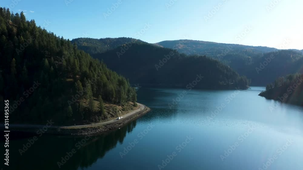 Aerial video heading towards Beauty Bay on Coeur d'Alene Lake following a truck pulling a camper along the highway. Aerial video heading towards Beauty Bay on Coeur d'Alene Lake following a truck pulling a camper along the highway.