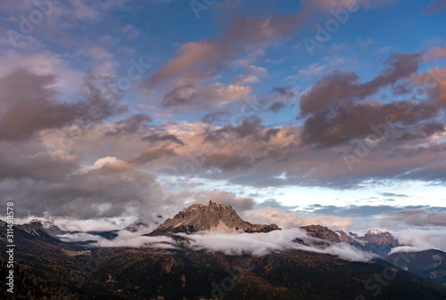 Dolomite mountains surrounded by clouds in South Tyrol, Italy /View from Lago di Sorapis hiking trail, during sunset in Autumn season / High ISO image