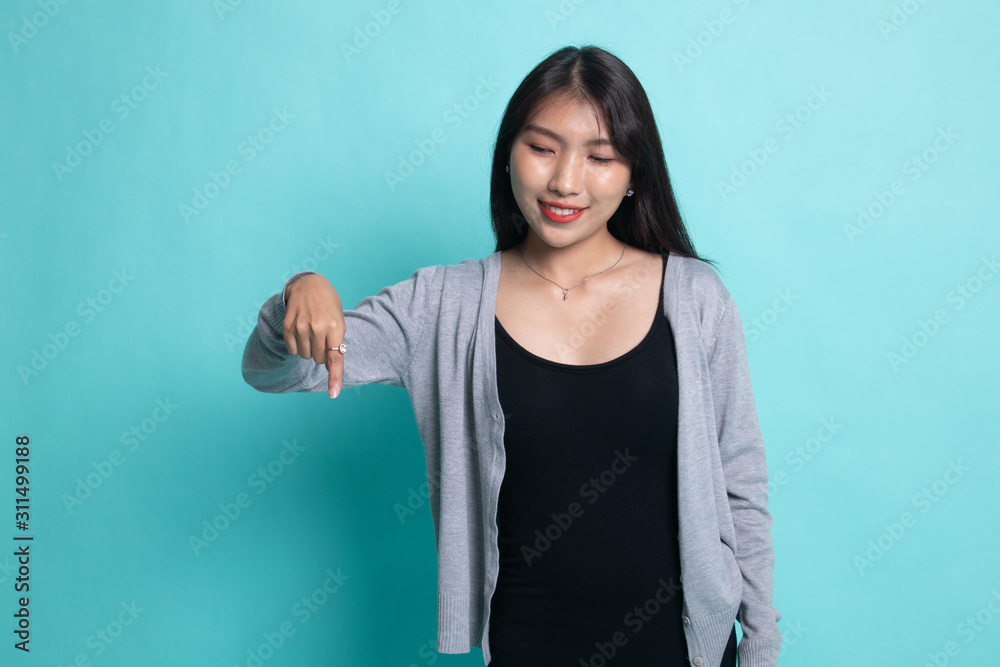 Beautiful young Asian woman point down to blank space. Beautiful young Asian woman point down to blank space.