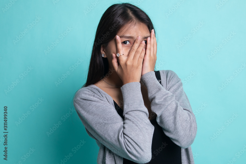 Beautiful young Asian woman peeking through fingers. Beautiful young Asian woman peeking through fingers.