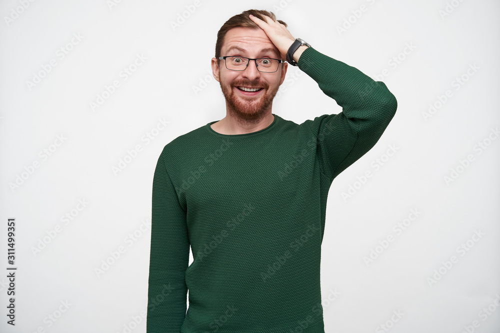 Amazed young handsome bearded man in eyewear rumpling his short brown hair and rounding surprisedly his eyes while looking at camera, isolated over white background Amazed young handsome bearded man in eyewear rumpling his short brown hair and rounding surprisedly his eyes while looking at camera, isolated over white background