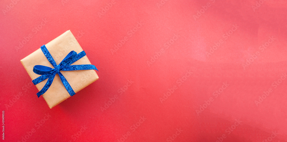 Flat lay of giftbox tied with classic blue color ribbon on blue background. 2020 color trend. Banner with place for text. Flat lay of giftbox tied with classic blue color ribbon on blue background. 2020 color trend. Banner with place for text.