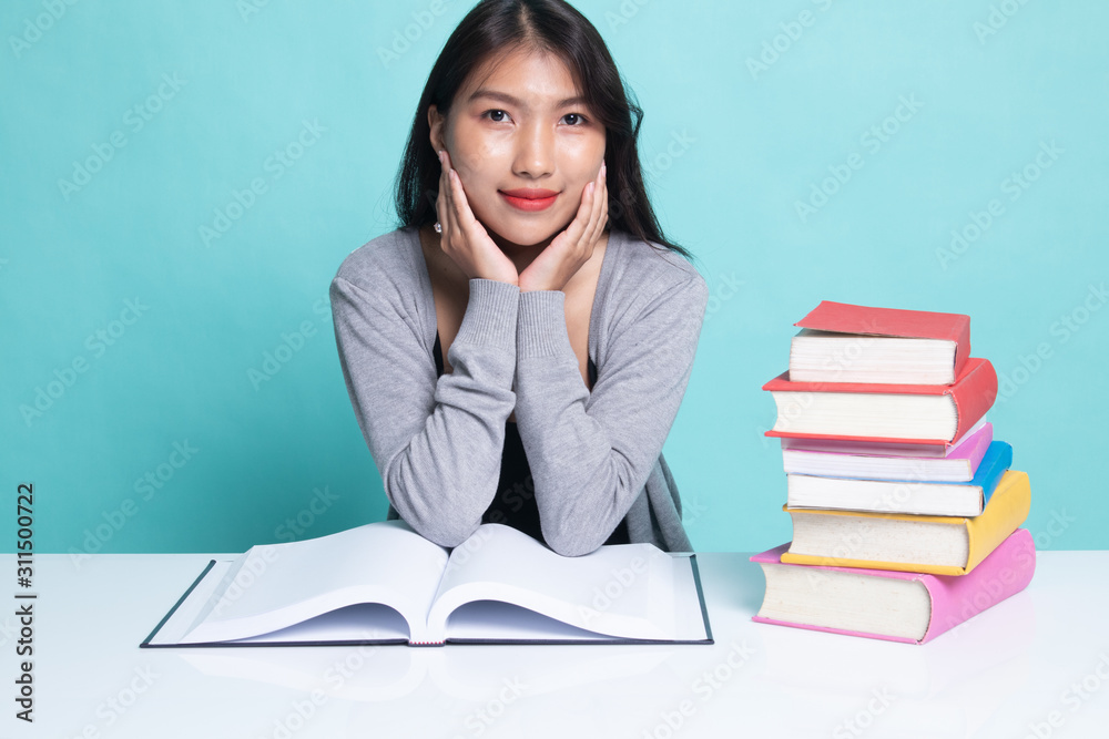 Young Asian woman read a book with books on table. Young Asian woman read a book with books on table.