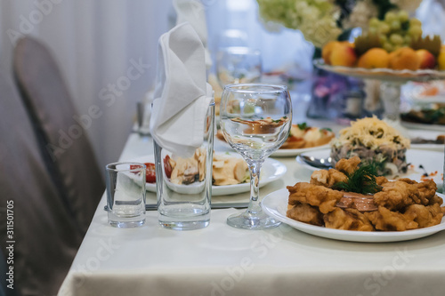 festive table in the restaurant with plates, glasses and Cutlery on a white tablecloth