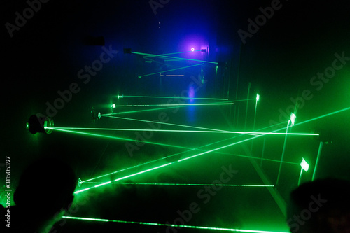 many green lasers bounce off walls along the way