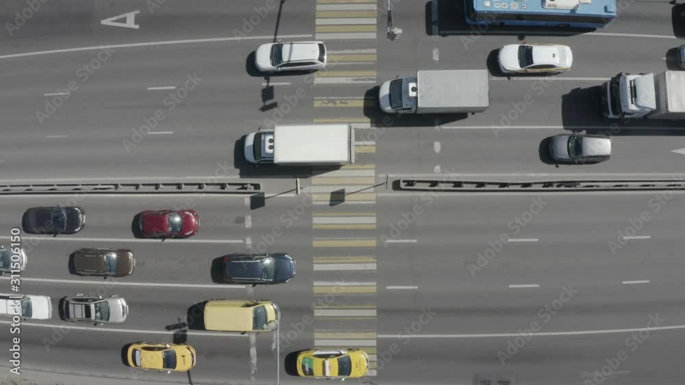 Aerial view of pedestrian crossing road. Cars stop in front of a traffic light. Street with people crossing crosswalk, go on the road. City life. Moscow, Russia. Aerial view of pedestrian crossing road. Cars stop in front of a traffic light. Street with people crossing crosswalk, go on the road. City life. Moscow, Russia.