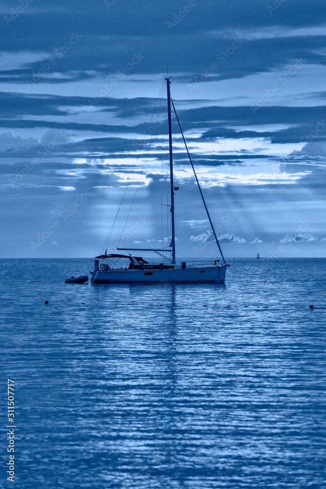 Beautiful evening Adriatic sea, yacht and full moon, Croatia. Evening toned in blue seascape.