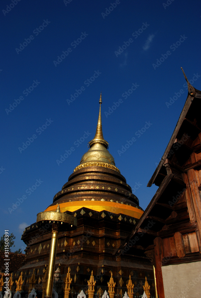 Fototapeta premium Golden Pagoda with blue sky, Phra That Lampang Luang.
