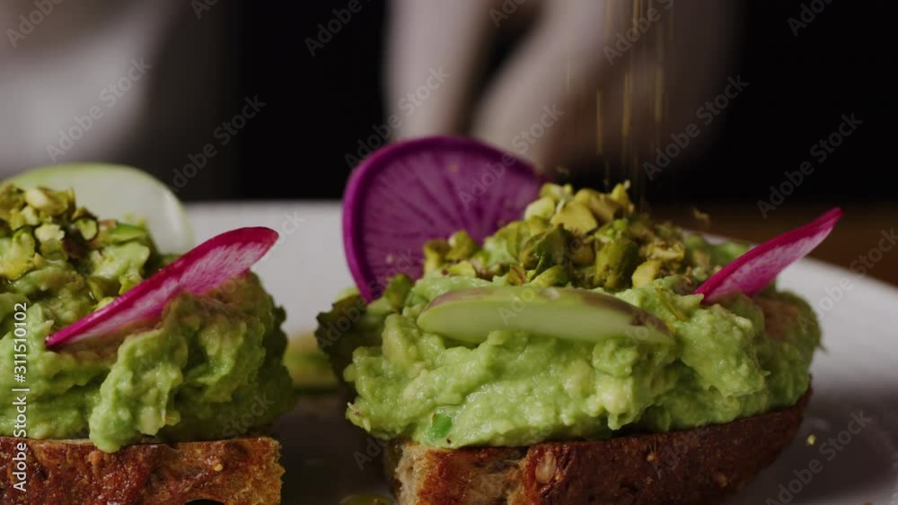 Putting slices of radish in squeezed avocado macro shot, cooking avocado toast, slow motion, vegan meal, shot on Red Weapon Helium Putting slices of radish in squeezed avocado macro shot, cooking avocado toast, slow motion, vegan meal, shot on Red Weapon Helium