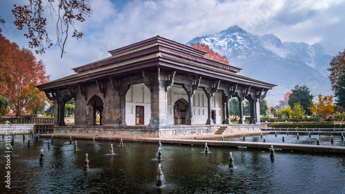 Mughal Heritage Building with snoe covered Zabarwan Mountains in the background during Autumn in Shalimar Bagh Mughal Garden of Kashmir