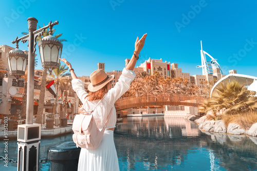 Photography happy girl admires the beautiful view of the Madinat Jumeirah Hotel and Mall