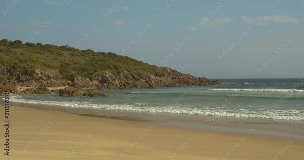 Wide shot of waves crashing near the headland of the historic, exotic fishing spot, Dark Point Beach, Hawks Nest, NSW, Australia on a perfect summer day with waves rolling in Wide shot of waves crashing near the headland of the historic, exotic fishing spot, Dark Point Beach, Hawks Nest, NSW, Australia on a perfect summer day with waves rolling in