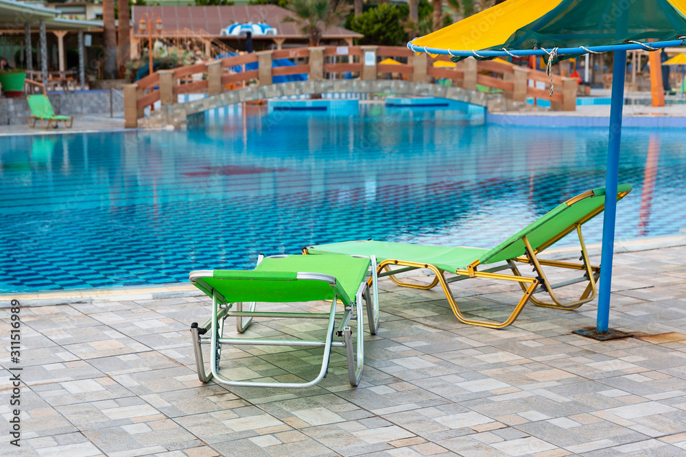 two sun loungers and an umbrella by the pool in a recreation area of ​​the Spanish city of Magaluf