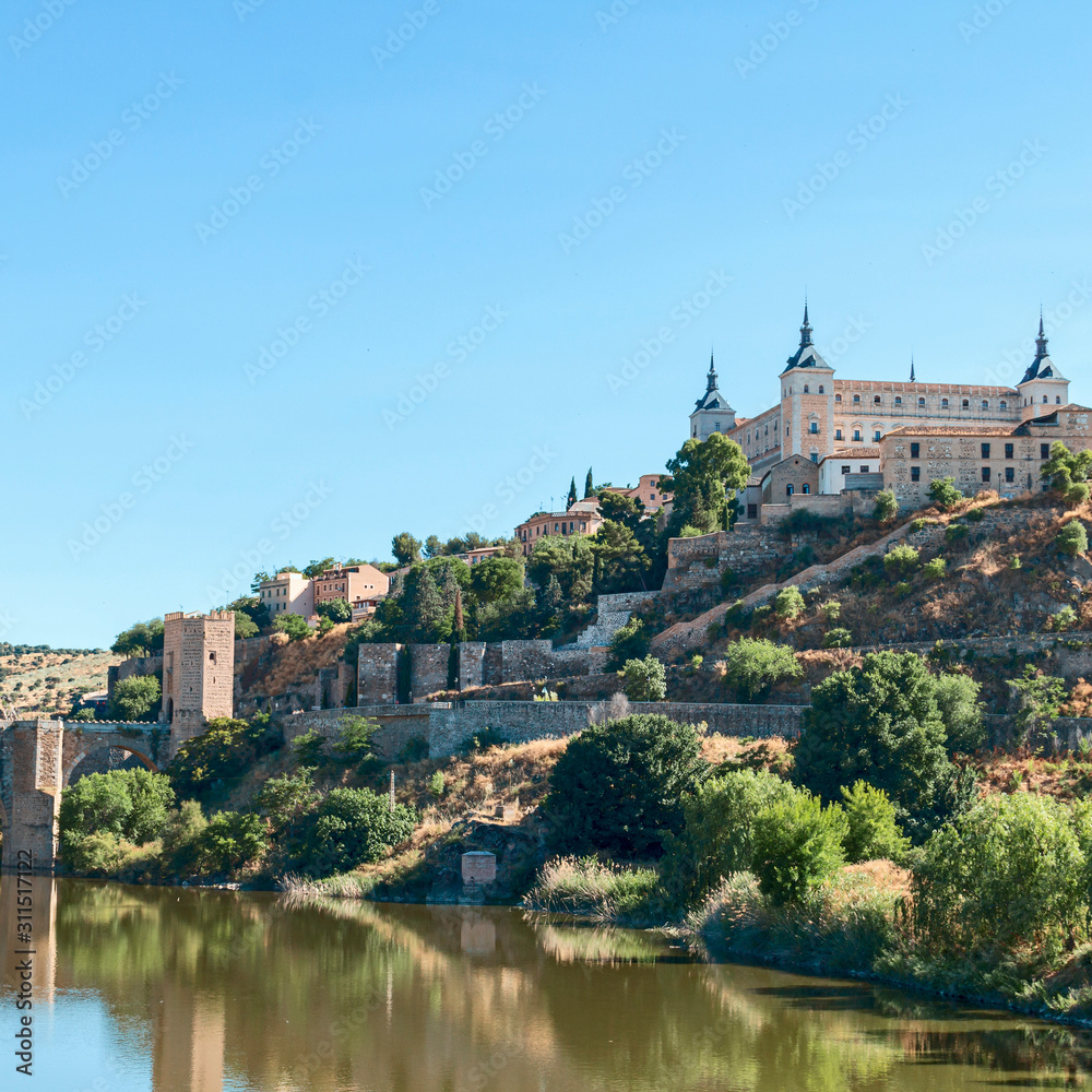 view from the river bank on the fortress wall and castles of the ancient Spanish city of Toledo