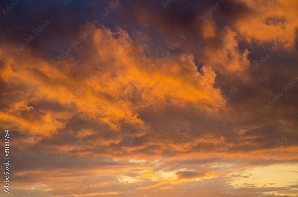 Orange dramatic cumulus clouds at sunset. Backlight