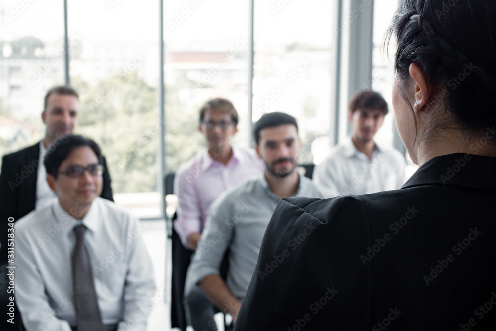 Asian woman offering information to people on the team in meeting. Asian woman offering information to people on the team in meeting.