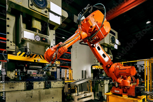 Large factory robot is operating an assembly line job
