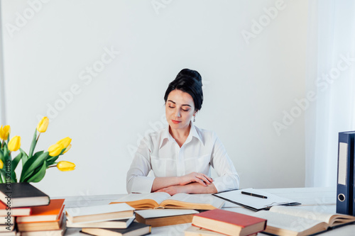 brunette woman in a business suit reads books in the Office