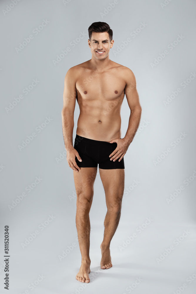 Handsome man in black underwear on light grey background